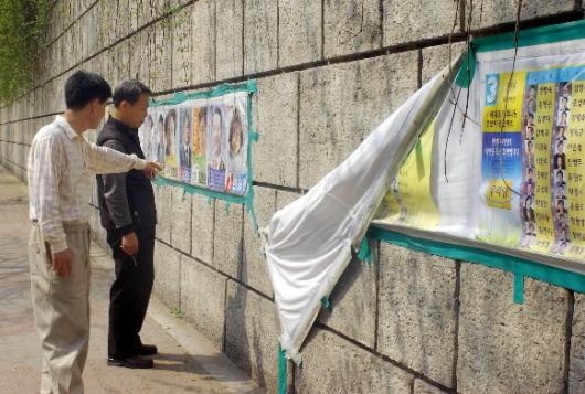 선거관리위원회가 선거벽보를 개인소유 주택의 담이나 건축물에도 무분별하게 붙여 시비가 잦은 가운데 13일 서울 동대문구 회기동의 한 공공건물 벽에 붙여놓은 선거벽보가 훼손돼 도시미관을 해치고 있다. 정연호기자 tpgod@