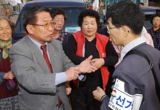 13일 부산 부전시장에서 열린 한 정당의 유세에서 선관위 직원(오른쪽)과 선거운동원이 선거 플래카드의 위법성 여부를 놓고 실랑이를 벌이고 있다. 부산 최해국기자 seaworld@