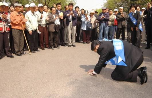 총선 선거운동 마지막 날인 14일 서울 종묘공원에서 한 후보가 땅바닥에 엎드려 유권자들에게 큰 절을 올리고 있다. 최해국기자 seaworld@