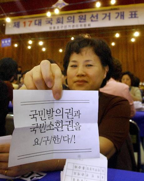 15일 밤 서울 영등포구의 개표소인 여의도고교에서 한 개표위원이 투표함에서 발견한 ‘국민발의권 및 소환권’을 요구하는 쪽지를 들어보이고 있다. 정연호기자 tpgod@