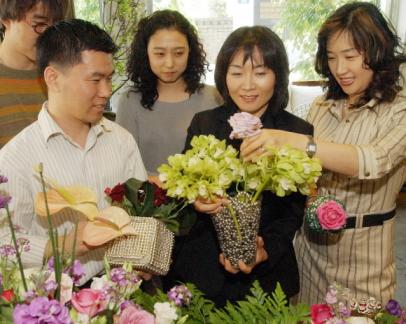 유영실(오른쪽에서 두번째)씨가 꽃 장식가 김종욱(앞줄 왼쪽)씨와 후배들이 지켜보는 가운데 은빛 볼폼이 담긴 유리화병에 꽃을 꽂고 있다. 김명국기자 daunso@