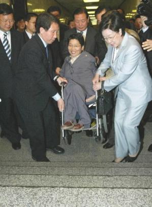 22일 오전 휠체어를 타고 국회 현장방문에 나선 열린우리당 장향숙(가운데)당선자가 김근태(왼쪽) 원내대표와 한명숙 당선자 등의 도움으로 계단을 오르고 있다. 남상인기자 sanginn@
