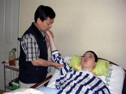 어버이날을 하루 앞둔 7일 인천호프집 화재로 5년째 식물인간으로 지내는 석영씨의 팔을 아버지 정윤용씨가 정성스레 주무르고 있다. 인천 고금석기자 kskoh@