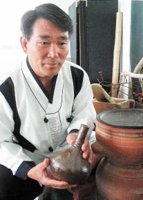 아버지의 유언을 듣고 '추성주' 재현에 나서 명인 22호가 된 양대수씨가 소주고리에서 막 증류된 술을 들고 있다.