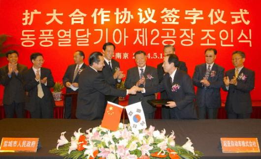 13일 중국 난징시 지링호텔에서 열린 기아차 중국 제2공장 조인식에서 정몽구(뒤편 오른쪽에서 4번째) 회장이 지켜보는 가운데 윤국진(앞줄 오른쪽) 기아차 사장과 자오펑 옌청시 인민정부 시장이 투자협의서를 교환한 뒤 악수하고 있다.기아차 제공