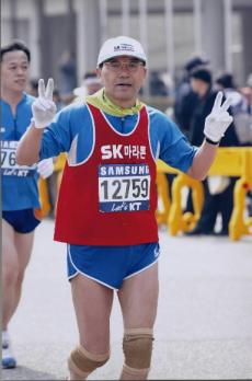 신 사장이 불우이웃 돕기 마라톤대회에서 완주하고 있는 모습.</B> SK제공