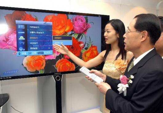 삼성전자 디지털미디어연구소 박노병(오른쪽) 부사장이 1일 삼성 서울 태평로 빌딩에서 열린 홈네트워크 신기술 ‘애니넷 발표회’에서 TV 화면을 보며 리모컨으로 DVD 콤보를 조작하고 있다. 이종원기자 jongwon@seoul.co.kr