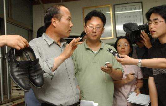 투신한 불량만두 제조업체 신씨의 유류품을 용산서 형사1반장이 기자들에게 설명하고있다. 안주영기자 jya@