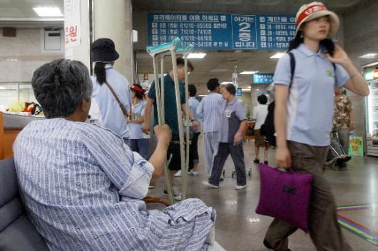 전국보건의료노조의 파업 닷새째인 지난 14일 고려대 병원 로비를 점거하고 있던 조합원이 환자 옆을 지나 병원을 나서고 있다. 정연호기자 tpgod@seoul.co.kr