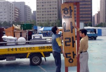 한나라당이 서울 염창동 새 당사에 입주하기 전날인 15일 이삿짐 센터 직원들이 여의도 천막당사에 걸린 당 현판을 떼어내고 있다. 최해국기자 seaworld@seoul.co.kr