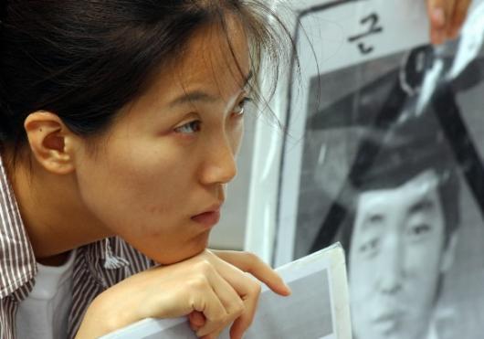 23일 서울 광화문 교보빌딩 앞 파병반대 집회에서 김선일씨 영정을 옆에 둔 한 시민이 허탈한 표정으로 그의 죽음을 애도하고 있다. 도준석기자 pado@seoul.co.kr