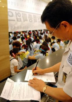 노사간 전국보건의료산업노조의 합의안에 대한 이견으로 20일째 파업이 계속되고 있는 서울대병원 로비에서 29일 청원경찰이 환자의 입퇴원 서류를 대신 써주고 있다. 김명국기자 daunso@seoul.co.kr