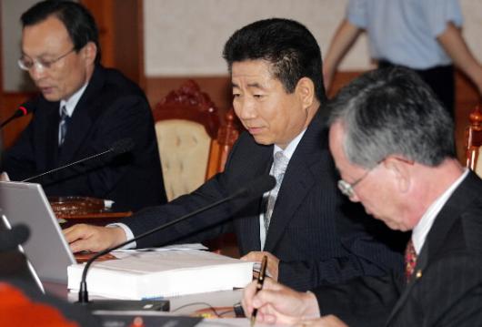 노무현 대통령이 20일 청와대에서 국무회의를 주재하며 노트북 PC에 수록된 자료를 살펴보고 있다.좌우로 이해찬 국무총리와 이헌재 경제부총리. 청와대사진기자단