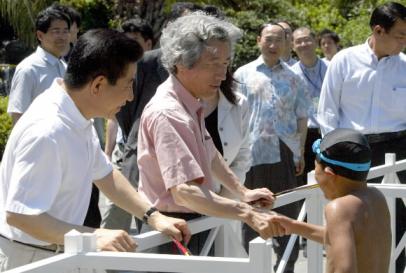 노무현(왼쪽) 대통령과 고이즈미 준이치로 일본총리가 22일 제주 신라호텔에서 산책을 하는 도중 수영하는 일본 어린이가 인사하자 반갑게 악수하고 있다. 류재림기자 jawoolim@seoul.co.kr