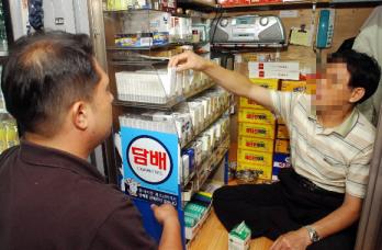 한 남성이 담배가게에서 담배를 구입하고 있…