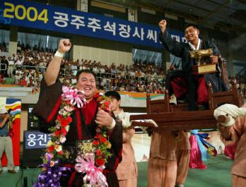 지난해 9월29일 공주에서 열린 추석장사대회에서 백두급 정상에 오른 백승일의 권유로 꽃가마에 오른 차경만(오른쪽) 감독이 기뻐하고 있다. 한국씨름연맹 제공