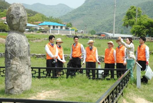 한화국토개발 용인골프장 직원들이 경기도 화성시 융건릉에서 ‘1문화재1지킴이’ 운동 참가에 앞서 문화재 전문가로부터 설명을 듣고 있다. 직원들은 이날 자체 장비를 이용해 제초 및 깎기·배토작업 등을 벌였다. 한화국토개발 제공