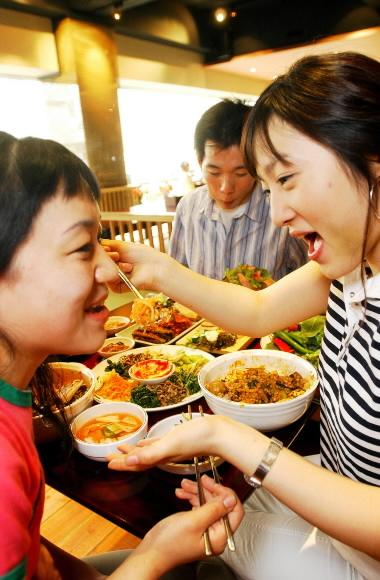 다이어트식으로 보리밥을 즐기는 신세대들. 서울 강남의 보리밥집 ‘사월에 보리밥’에서 김보연(오른쪽)씨가 친구 이진옥씨에게 보리밥을 익살스럽게 떠먹여주고 있다.