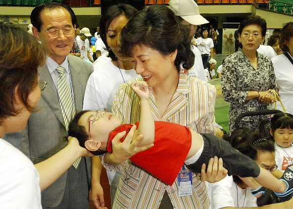 한나라당 박근혜 대표가 1일 장애아 치료를 위한 봉사활동 캠프가 열린 전북 익산 원광대를 방문, 장애 아동을 안은 채 격려하고 있다. 