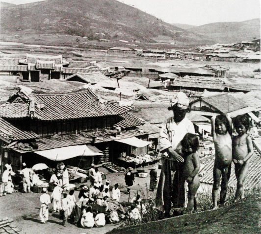 대동강 초입에 자리한 진남포. 한국인들과 일본인들(짙은 색 옷을 입은 사람들)이 자그마한 노천 시장에 모여 있다.