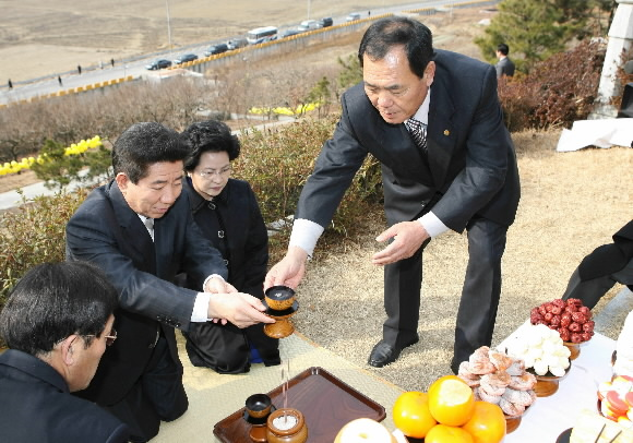 노무현 대통령이 19일 부인 권양숙 여사와 함께 고향인 김해 진영의 선친 산소를 찾아 잔을 올리고 있다.  