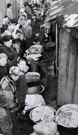 1970년대 초 세밑의 떡 방앗간은 집에서 불려온 쌀로 가래떡을 뽑기 위한 사람들로 문전성시를 이뤘다. 엄마 대신 줄 서 있는 까까머리 소년들은 바지속에 손넣어 지루함을 달래고, 저멀리 아낙네들은 팔장을 낀 채 언제 내 차례가 올지 헤아려 보고 있다. 요즘에는 볼 수 없는 설밑 풍경이 재미있다.