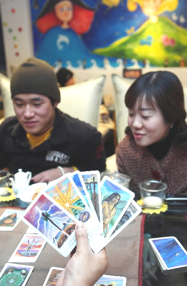 서울의 한 사주카페에서 젊은 남녀가 재미삼아 타로 카드로 점을 보고 있다. 