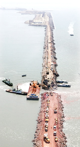 세계에서 가장 긴 새만금 방조제 33㎞ 물막이 공사가 착공 15년 만인 21일 완료됐다. 가력도 개방구간(1.6㎞) 가운데 마지막 남은 60m 구간을 바지선과 덤프트럭 등이 메우고 있다. 부안 도준석기자 pado@seoul.co.kr