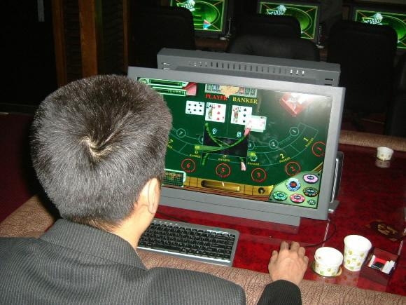 지난달 말 인천 부평의 한 카지노PC방에서 단속 경찰관이 ‘바카라’ 도박 사이트에 접속해 증거를 확보하고 있다. 경찰청 제공