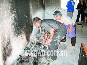 양중취안씨 부부가 화재로 그을린 부엌을 청소하고 있다. 중경만보 