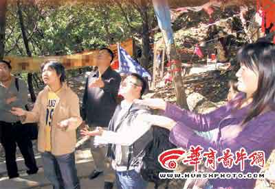 관광객들이 나무 밑에서 비가 많이 내리도록 박수를 친 뒤 손으로 빗방울을 받고 있다. 화상신보