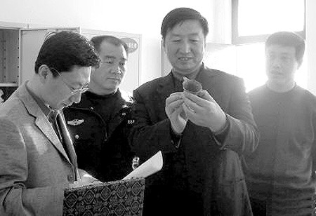 옌안 공안당국 관계자가 압수한 문화재를 살펴보고 있다.  화상보 