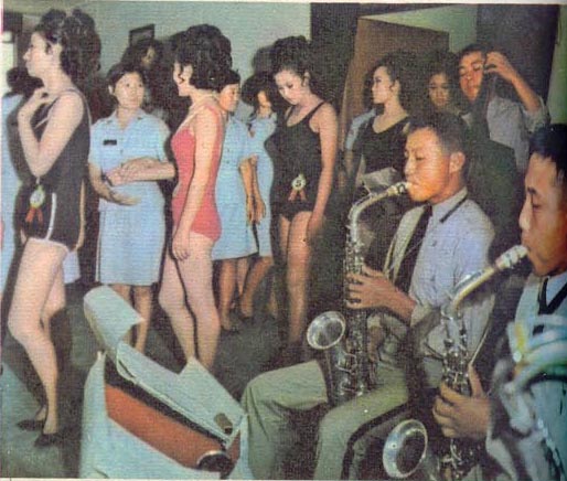 육군 군악대의 주악에 맞춰 수영복차림 심사를 위해 줄을 서 무대로 걸어가는 아가씨 군인들.