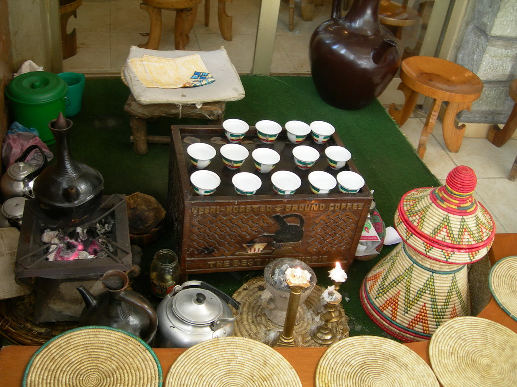 커피 전문점 실내 모습. 가게를 들어서자마자 커피 세러모니 도구들을 만날 수 있다. 커피 세러모니에 사용되는 화력은 전부 ‘숯’이다. 오른쪽에 보이는 의자는 다리가 넷이 아닌 셋인데 에티오피아 어디에서나 앉은뱅이 의자는 전부 다리가 셋이다. 맨 앞 오른쪽에 팽이를 엎어놓은 것 같은 화려한 장식품이 에티오피아 전통 스타일의 테이블이다. 뚜껑을 열면 속이 움푹한데 에티오피아 사람들은 이곳에 음료나 주식인 ‘인제라’를 올려놓고 세발 의자에 앉아 식사를 한다.