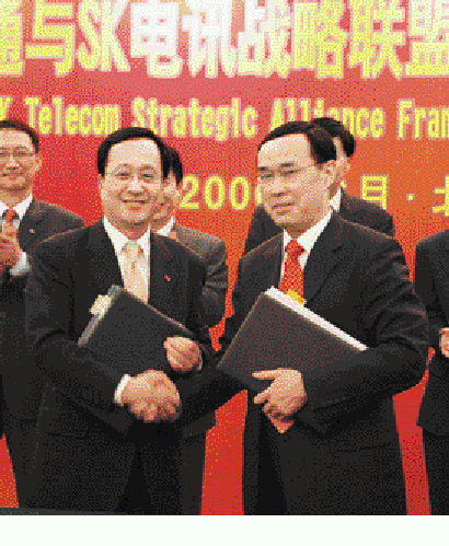 지난 6월 베이징의 인민대회당에서 김신배(왼쪽) SK텔레콤 사장이 차이나 유니콤 창샤오빙 회장과 전략적 제휴를 맺은 뒤 악수하고 있다. SK텔레콤 제공