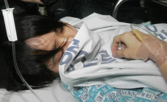 학력위조 혐의를 받고 있는 신정아 전 동국대 교수가 19일 서울 천호동 강동가톨릭병원에서 신장 초음파 검사를 받은 뒤 얼굴을 이불에 파묻은 채 병실로 옮겨지고 있다. 손형준기자 boltagoo@seoul.co.kr