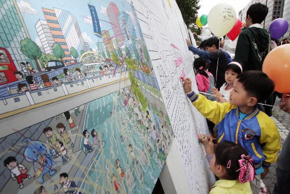 30일 청계천 복원 2돌을 맞아 청계천을 찾은 어린이들이 ‘가을 그리는 대형 그림판’ 앞에서 크레파스로 색칠을 하고 있다. 최해국기자 seaworld@seoul.co.kr