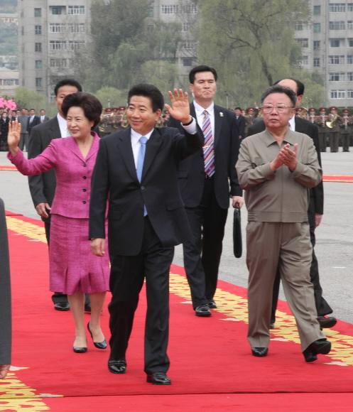 노무현 대통령과 권양숙 여사가 2일 낮 평양 4·25문화광장에서 열린 공식 환영식에서 김정일 국방위원장의 안내를 받으며 환영 군중에게 손을 흔들어 인사하고 있다. 평양 청와대사진기자단