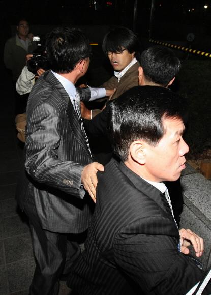 국세청 직원·사진기자 몸싸움 국세청 직원들이 23일 서울 국세청사 앞에서 청장의 뇌물수수 의혹을 취재하는 연합뉴스 사진부 서명곤(뒤쪽 안경쓴 이) 기자를 제지하고 있다.