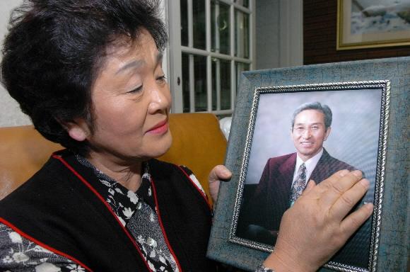 1982년 ‘송씨 일가 간첩사건’의 피해자 송기복씨가 24일 서울 관악구 신림동 자택에서 죽은 남편의 사진을 어루만지며 눈시울을 붉히고 있다. 이호정기자 hojeong@seoul.co.kr