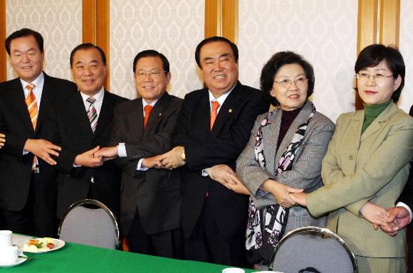 대통합민주신당 문희상(오른쪽에서 세번째) 상임고문과 민주당 최인기(왼쪽에서 세번째) 원내대표 등 합당 실무협상단 의원들이 15일 국회 귀빈식당에서 만나 회의에 앞서 사진기자들을 위해 손을 맞잡는 포즈를 취하고 있다. 김명국기자 daunso@seoul.co.kr