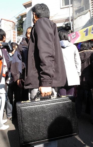 이회창 후보 캠프 관계자 손에 들린 007가방. 캠프 관계자들은 지방순회때마다 이 가방을 들고 다닌다. 김명국기자 daunso@seoul.co.kr