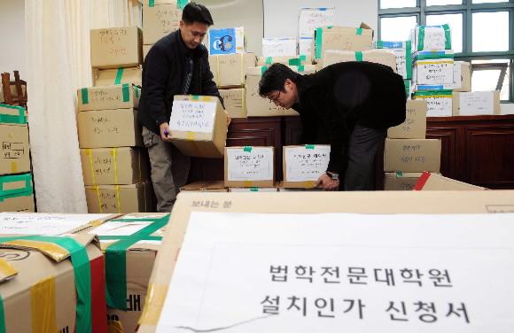 법학전문대학원 설치인가 신청 마지막 날인 30일 서울 세종로 중앙정부청사 별관 교육혁신위원회에서 청사 직원들이 각 대학이 접수한 서류들을 옮기고 있다. 정연호기자 tpgod@seoul.co.kr