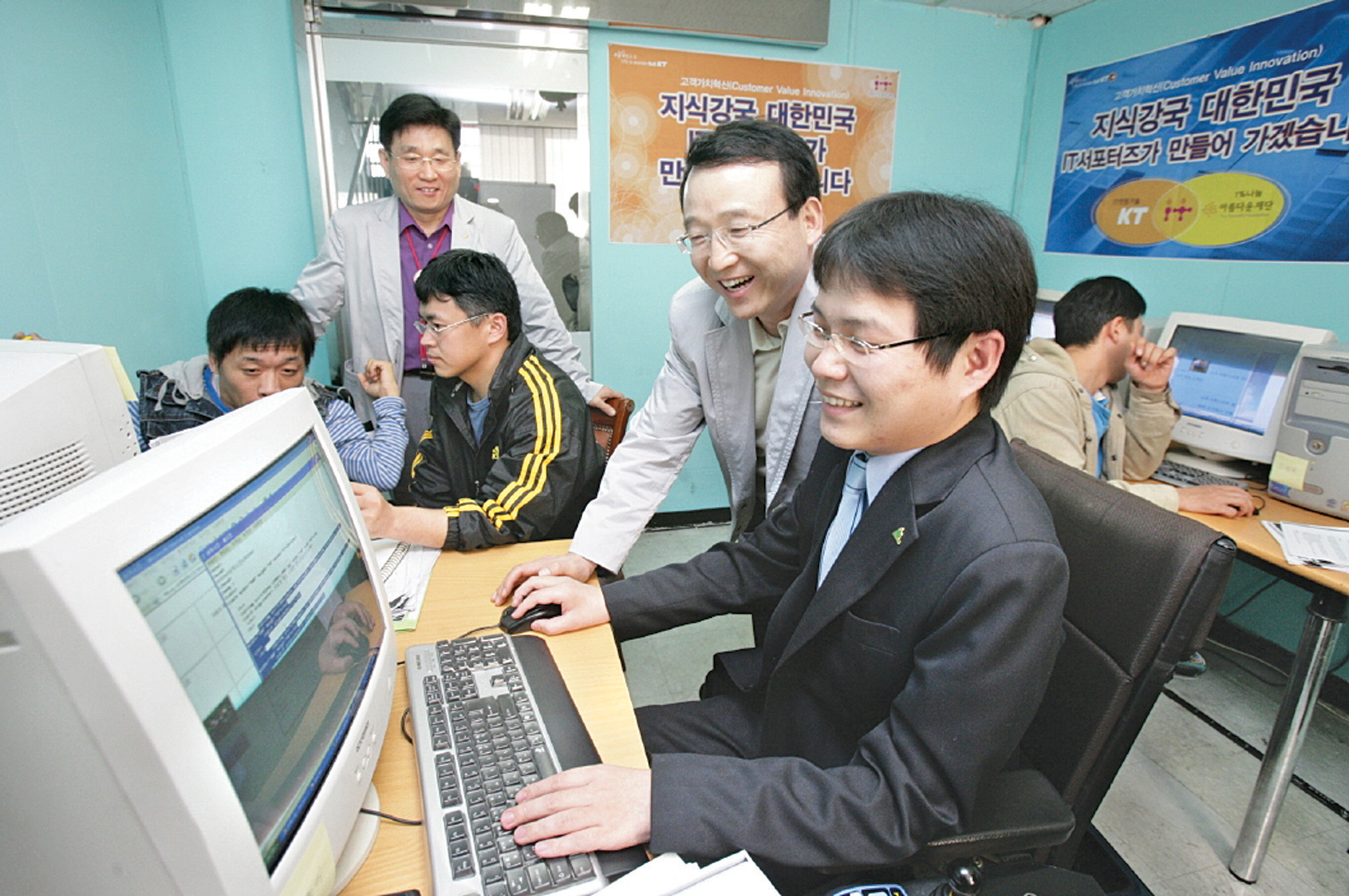 IT 서포터스 활동에 참가한 남중수 사장이 컴퓨터 활용기술을 가르치고 있다. KT 제공