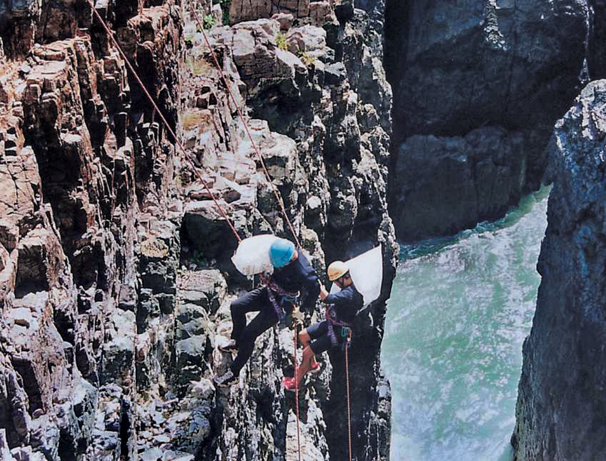 지역환경 지킴이를 자처하는 사내 산악인 봉사모임 ‘바구회’ 회원들이 자일에 의지해 해안절벽의 쓰레기를 치우고 있다. 한진중공업 제공