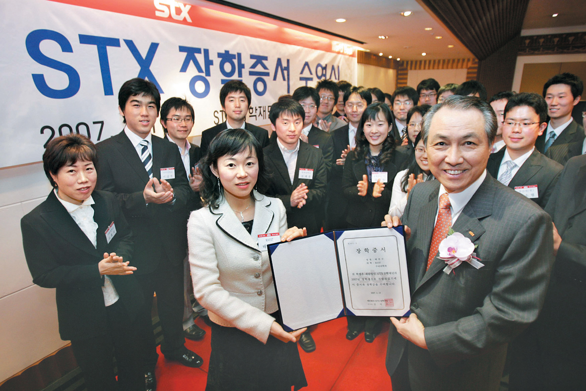 강덕수(오른쪽) 회장이 올 4월 뽑은 STX 장학재단 1기 장학생에게 장학증서를 전달하고 있다. STX그룹 제공