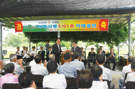 지난 2005년 현대증권 김지완(왼쪽) 사장이 전남 영암군 망호정 마을과 자매결연을 맺은 뒤 악수를 나누고 있다. 현대증권 제공