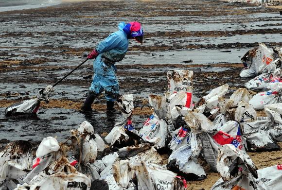기름 유출사고로 해안가 일대가 크게 오염된 충남 태안군 의향리 주민이 10일 기름을 수거한 자루를 힘겹게 한 곳에 모으고 있다. 태안 도준석기자 pado@seoul.co.kr