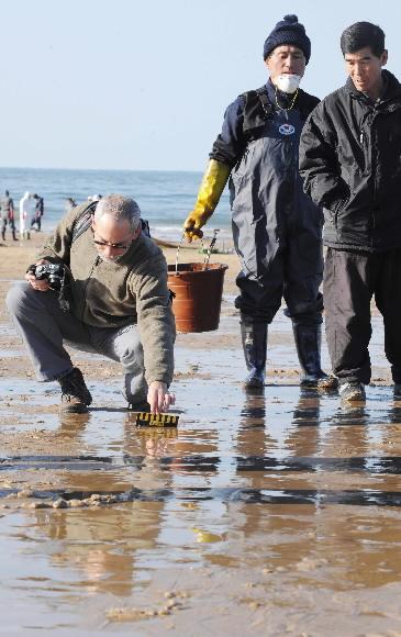 14일 유출된 원유의 방제작업을 돕기 위해 전날 입국한 미국 방제팀이 충남 태안군 만리포 해안에서 자료를 수집하고 있다. 태안 정연호기자 tpgod@seoul.co.kr