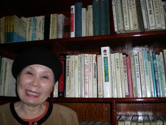 남편 정도영(1999년 작고)씨가 남긴 책 앞에서 활짝 웃음 짓는 박춘씨.